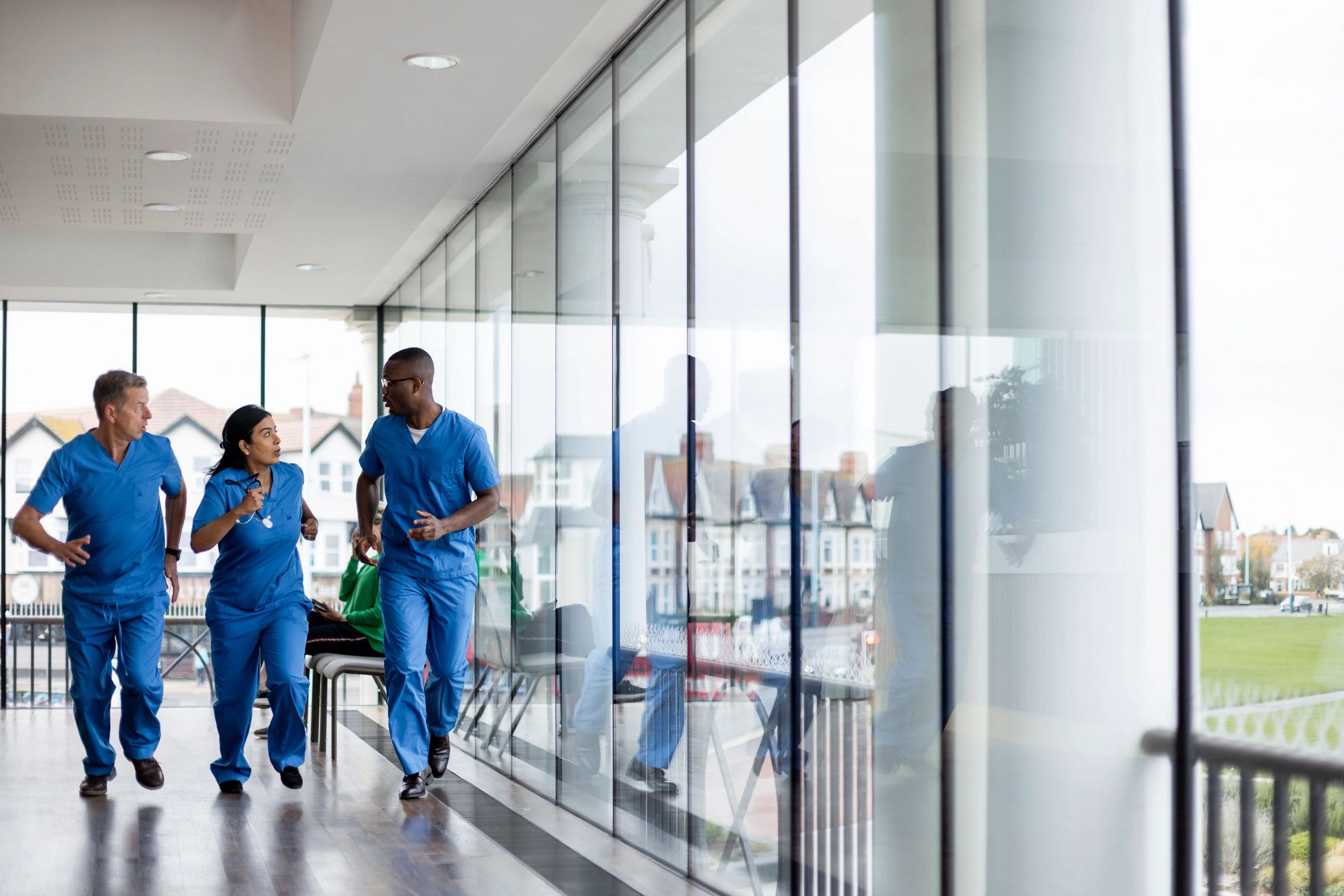 Medical professionals running down a hospital corridor