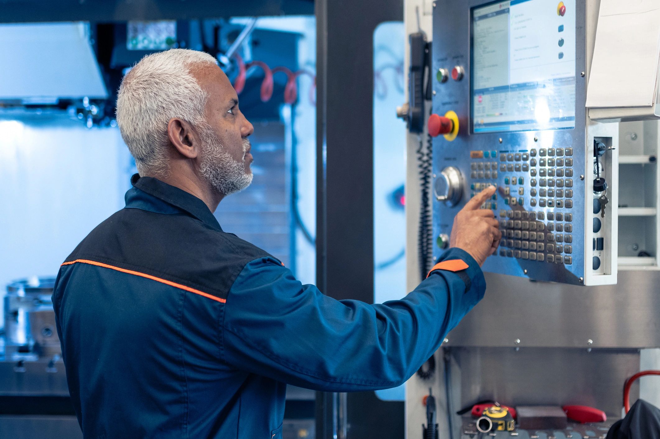 CNC machine operator monitoring precision manufacturing equipment